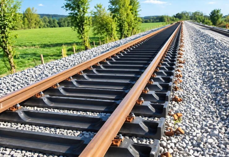Stacked black UHMWPE plastic railway sleepers with precision pre-drilled holes, showing clean surface finish and engineered polymer quality